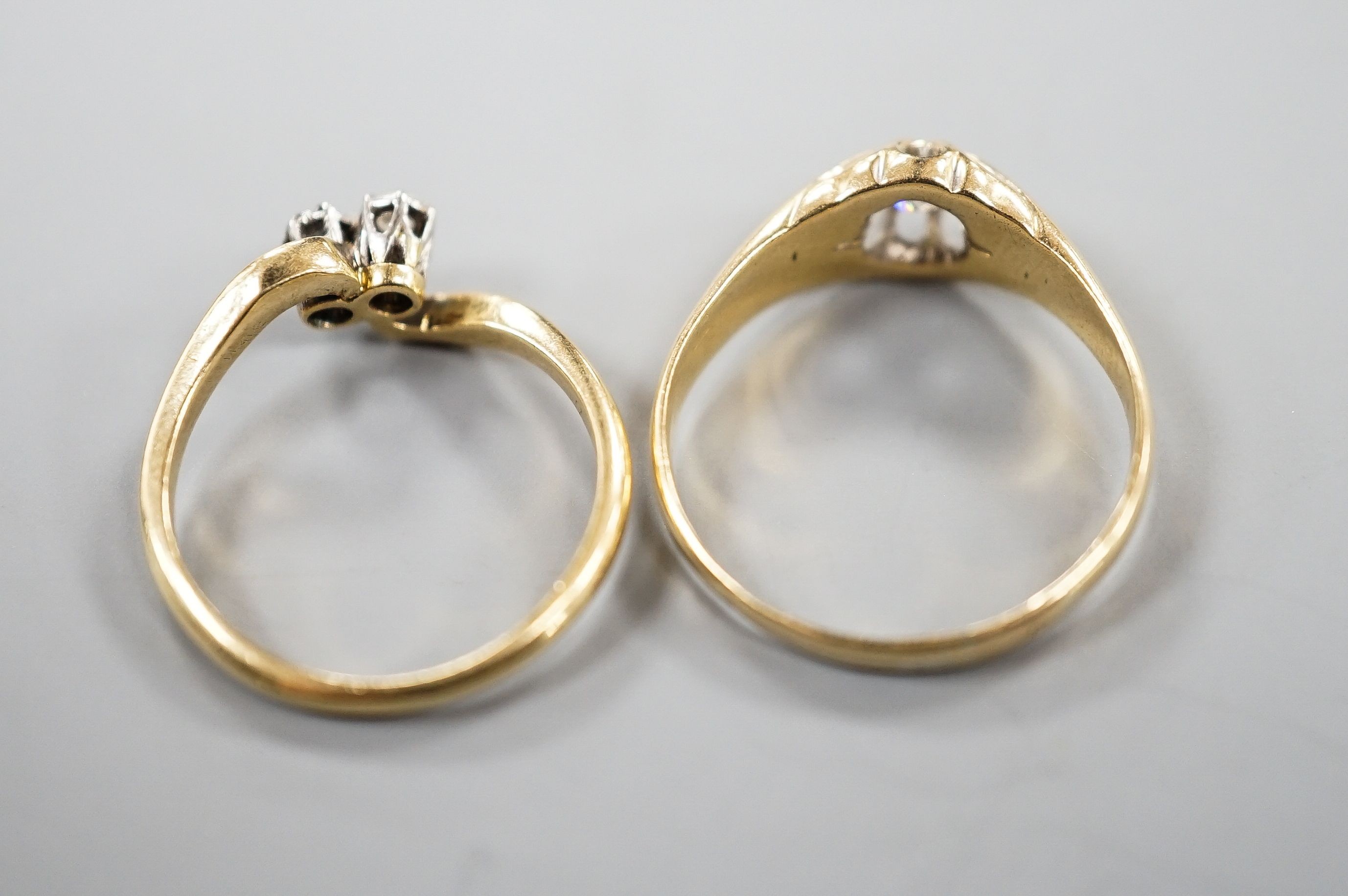 An early 20th century 18ct gold and claw set solitaire diamond ring, size O and an 18ct & Pt, two stone diamond set crossover ring, size K, gross weight 5.7 grams.